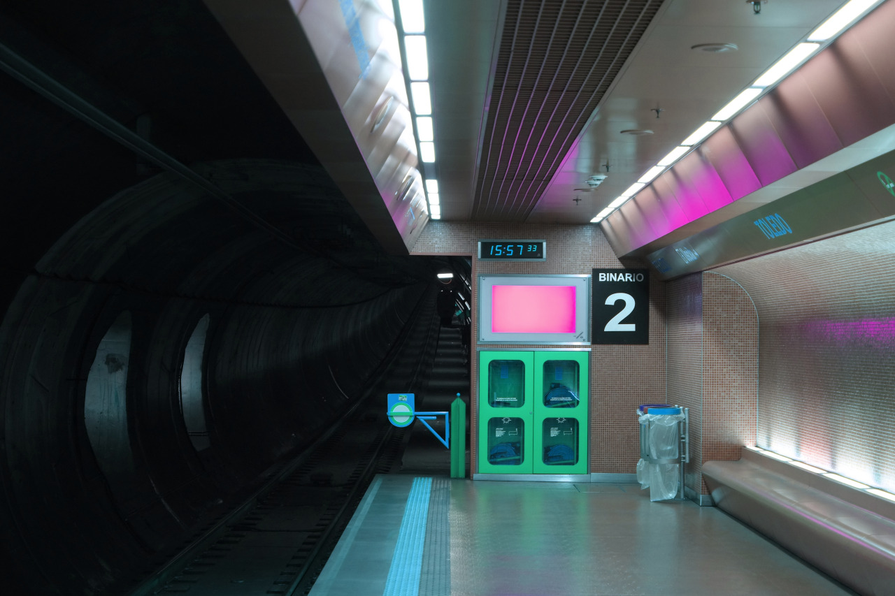 The meme is a picture of a dark and empty train station platform, with a single fluorescent light flickering overhead. The text "15:57" is displayed on a screen above the platform, indicating that a train is delayed. The image is captioned "when you finally get to the platform and it's just you waiting for a train that's never coming".